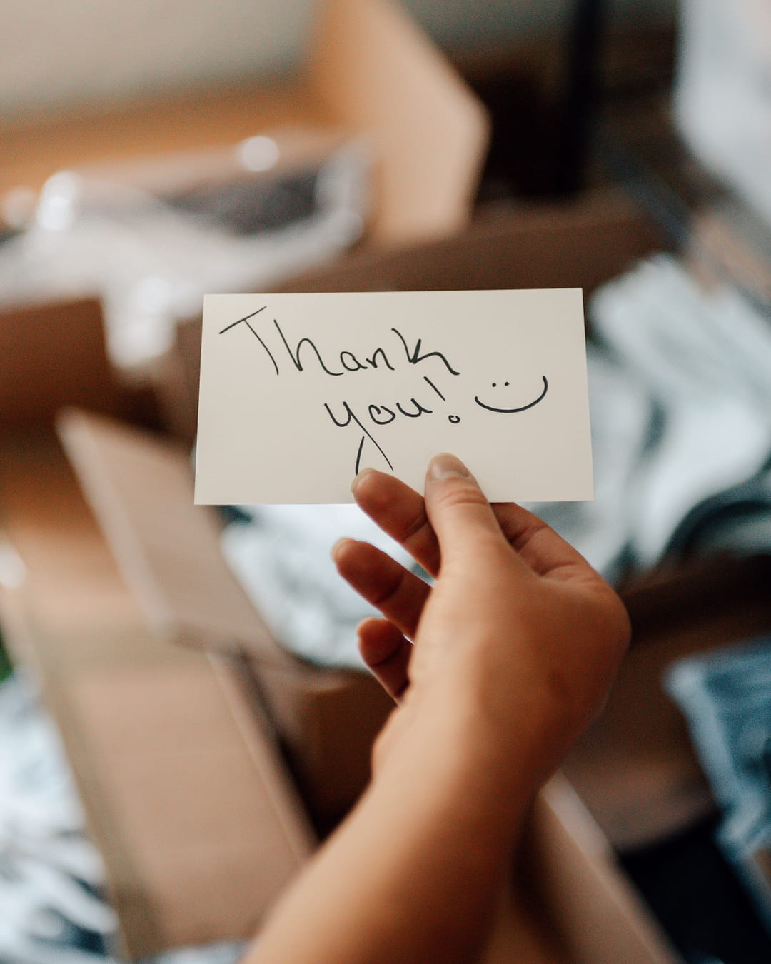 Handwritten thank you card being added to a package
