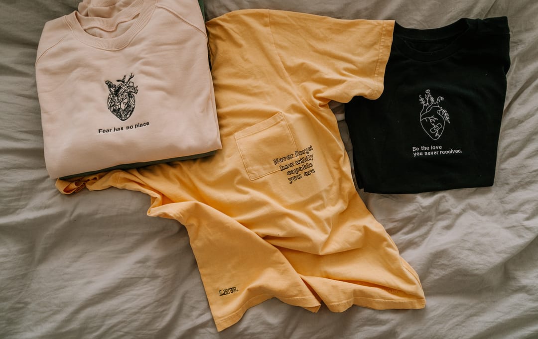 3 shirts laid out on a bed